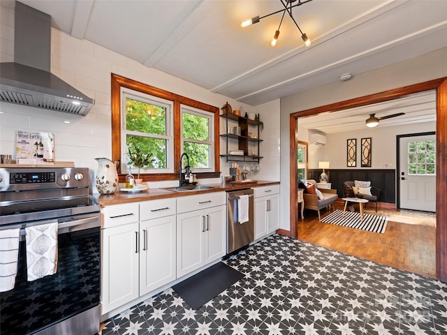 68 Piney Mountain Church Rd, Candler, NC 28715 - kitchen with butcher block counters, wall chimney range hood, tile patterned floors, a sink, and stainless steel appliances