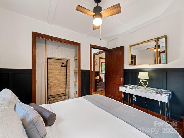 68 Piney Mountain Church Rd, Candler, NC 28715 - bedroom featuring a ceiling fan, wainscoting, and a decorative wall