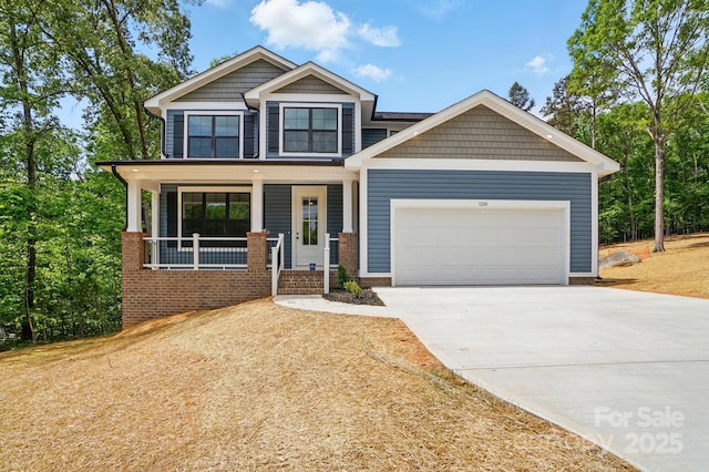 craftsman-style house featuring covered porch, an attached garage, and concrete driveway