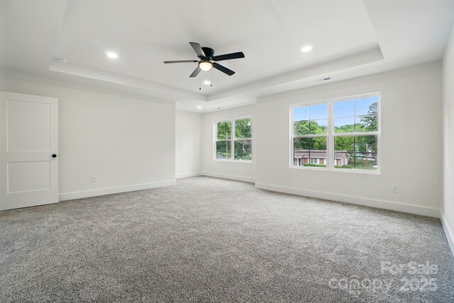 carpeted spare room with a raised ceiling, baseboards, a ceiling fan, and recessed lighting