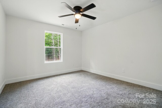 spare room with carpet flooring, a ceiling fan, baseboards, and visible vents