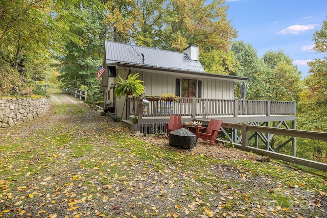 197 Gardenside Rd, Mars Hill, NC 28754 - rear view of house featuring a fire pit, a wooden deck, a chimney, and metal roof