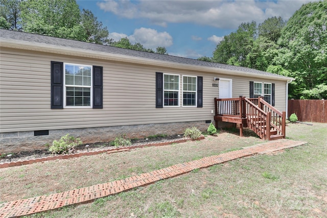 view of front of home featuring fence, a front yard, and crawl space