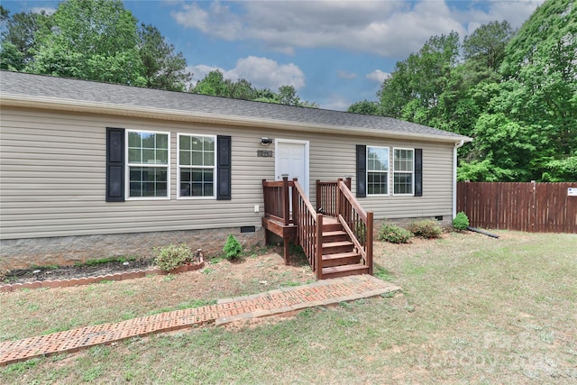 view of front of house featuring fence, a front lawn, and crawl space