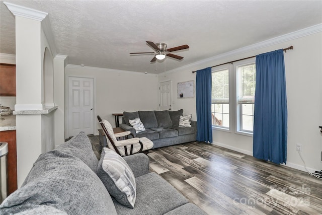 living room with crown molding, ceiling fan, and wood finished floors