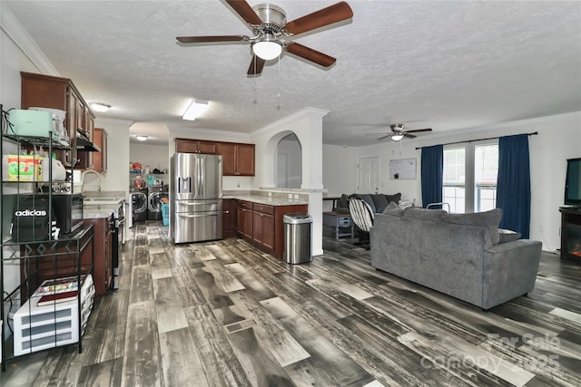 living room featuring a textured ceiling, ceiling fan, independent washer and dryer, and dark wood-style floors