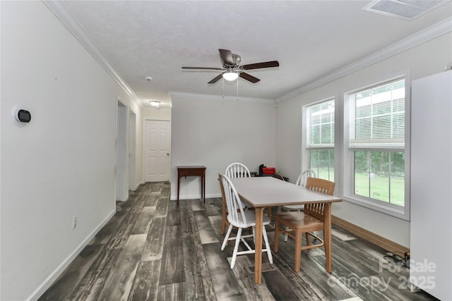 dining space featuring visible vents, ornamental molding, dark wood-style flooring, baseboards, and a ceiling fan