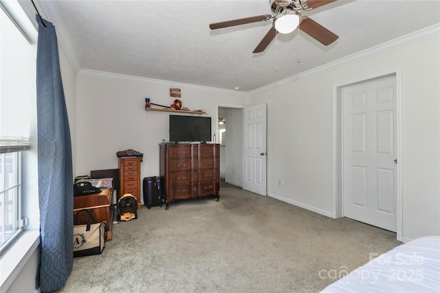 carpeted bedroom featuring crown molding, a ceiling fan, and baseboards