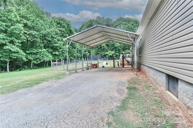 view of parking featuring fence, a carport, and driveway