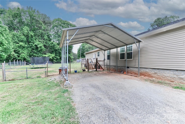 exterior space with a detached carport, fence, and gravel driveway