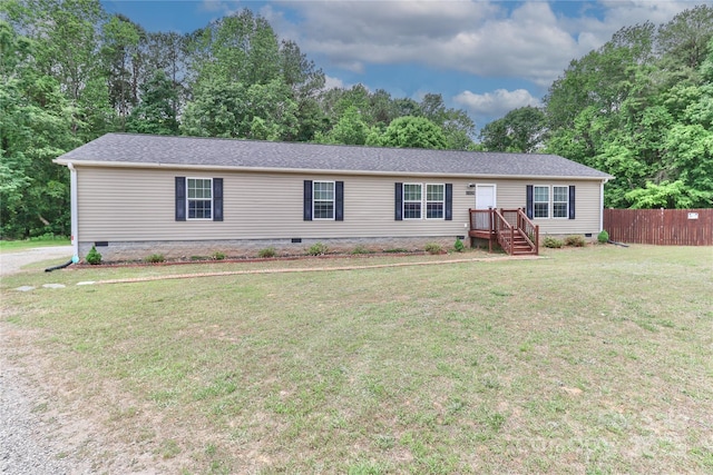 view of front facade featuring fence, a front yard, and crawl space