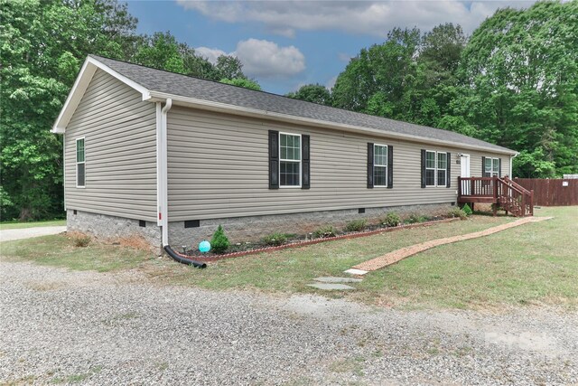 view of front facade with crawl space, fence, a shingled roof, and a front lawn