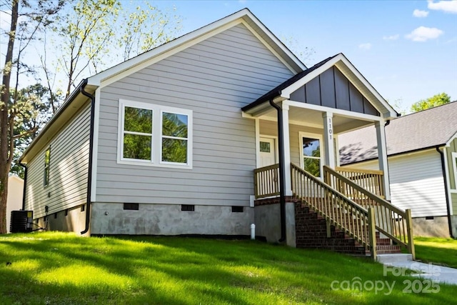 view of front of home with a front lawn, central air condition unit, and crawl space