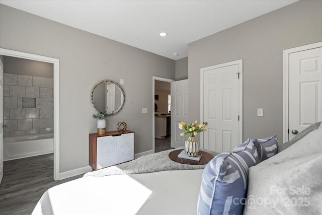 bedroom featuring baseboards, wood finished floors, and connected bathroom