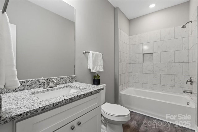 bathroom featuring vanity, toilet, wood finished floors, and tub / shower combination