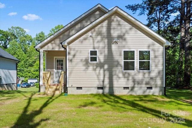 rear view of house featuring a yard and crawl space