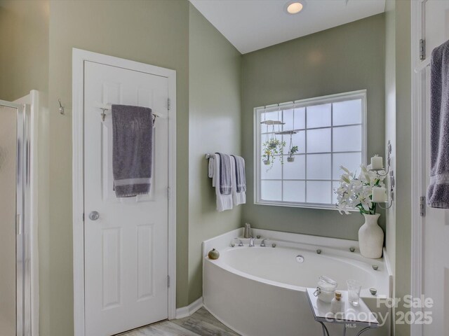 433 Linsbury Ct, Gastonia, NC 28056 - bathroom featuring a garden tub, baseboards, and wood finished floors