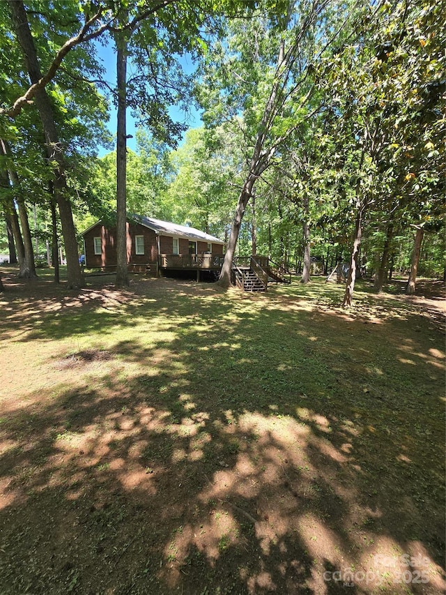 view of yard with stairs and a deck