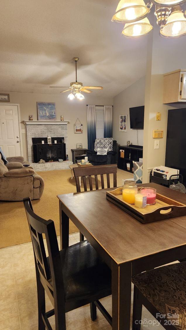 dining area with ceiling fan and a fireplace