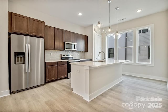 842 Van Every St, Charlotte, NC 28205 - kitchen featuring light countertops, stainless steel appliances, a sink, and light wood-style floors