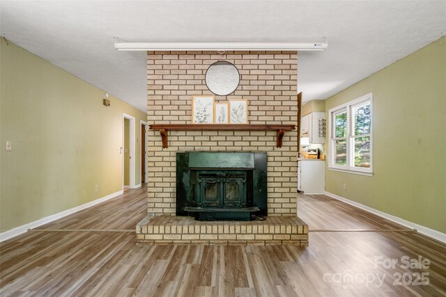 unfurnished living room featuring wood finished floors and baseboards