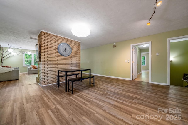 living room featuring a textured ceiling, wood finished floors, and baseboards