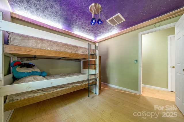 bedroom featuring wood finished floors and baseboards