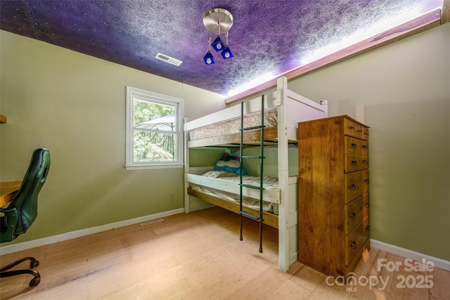 bedroom with wood finished floors and baseboards