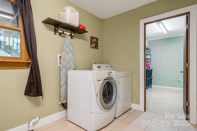 washroom with washer and clothes dryer and baseboards