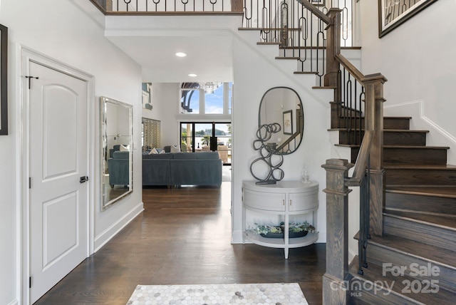 entryway featuring a high ceiling, a chandelier, stairs, recessed lighting, and wood finished floors