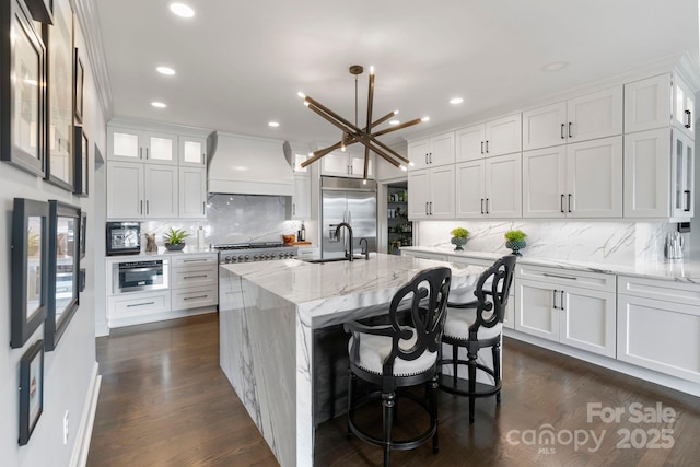 kitchen with custom exhaust hood, recessed lighting, stainless steel built in fridge, white cabinets, and backsplash