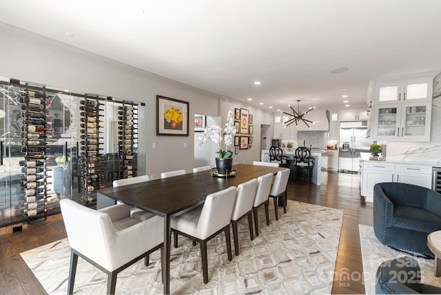 dining room with crown molding, light wood finished floors, and a notable chandelier