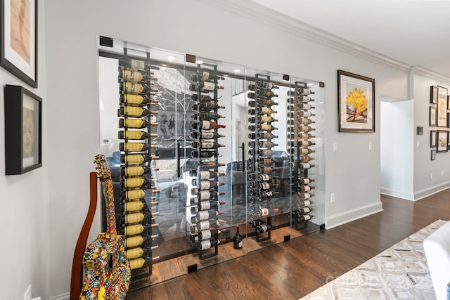 wine room with crown molding, baseboards, and wood finished floors