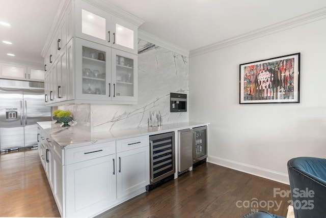 bar with decorative backsplash, built in fridge, ornamental molding, and wine cooler