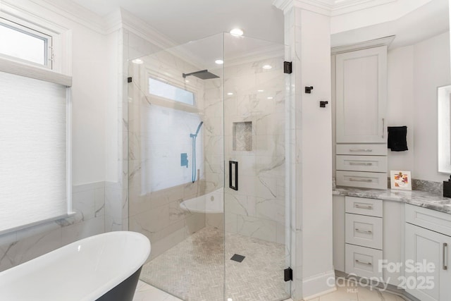 full bathroom with vanity, ornamental molding, a marble finish shower, and a freestanding bath