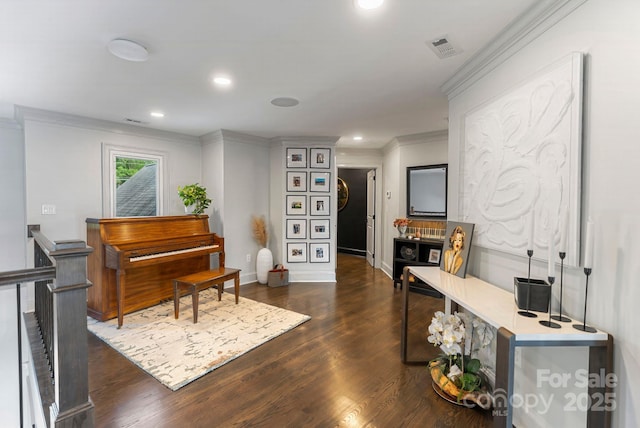 sitting room with dark wood-style flooring, recessed lighting, baseboards, visible vents, and ornamental molding