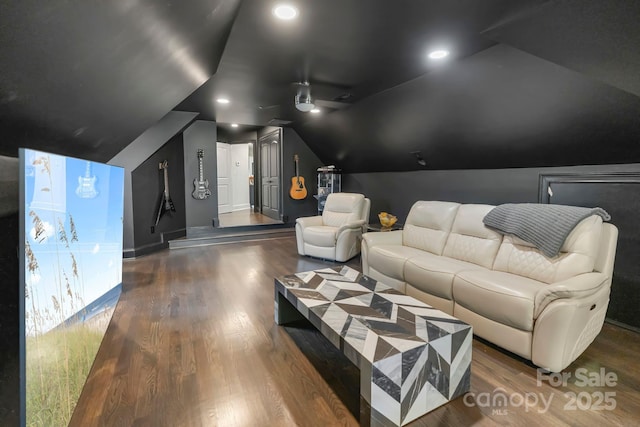 home theater featuring wood finished floors and vaulted ceiling