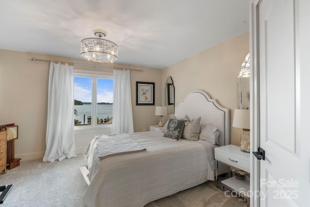 bedroom featuring baseboards, carpet, and an inviting chandelier