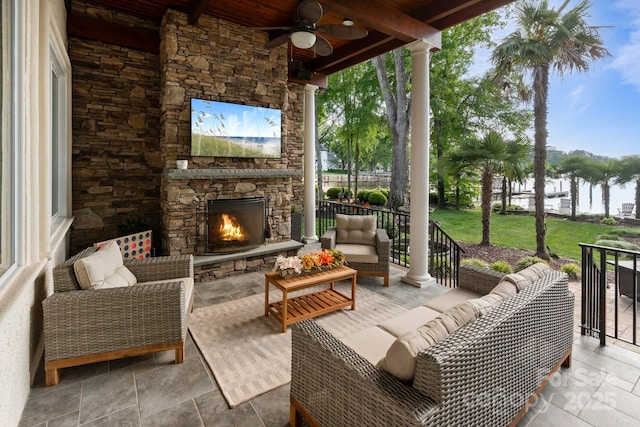 view of patio / terrace featuring a ceiling fan and an outdoor living space with a fireplace