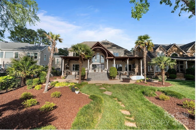 back of property with a patio, a lawn, fence, and stucco siding