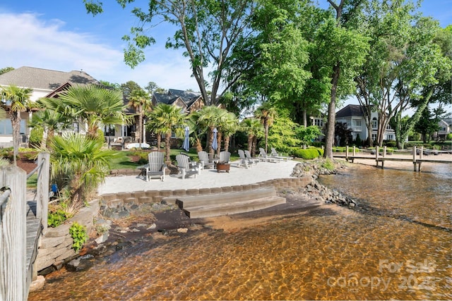 view of property's community featuring a boat dock and a water view