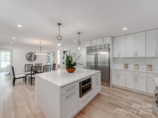3501 Providence Rd, Charlotte, NC 28211 - kitchen with stainless steel appliances, recessed lighting, decorative backsplash, light wood-type flooring, and a chandelier