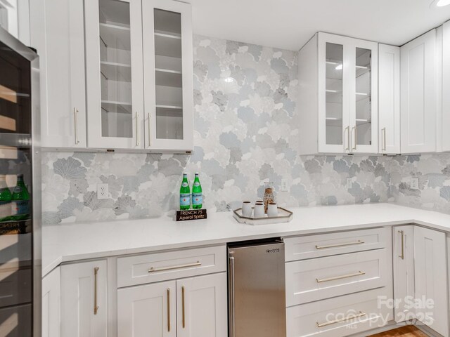 3501 Providence Rd, Charlotte, NC 28211 - kitchen with freestanding refrigerator, white cabinetry, light countertops, wallpapered walls, and glass insert cabinets