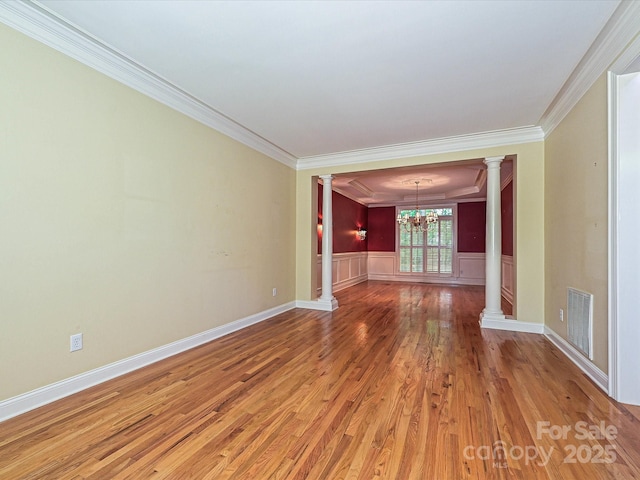 16511 Bridgehampton Club Dr, Charlotte, NC 28277 - empty room with decorative columns, ornamental molding, a chandelier, light wood-type flooring, and a wainscoted wall