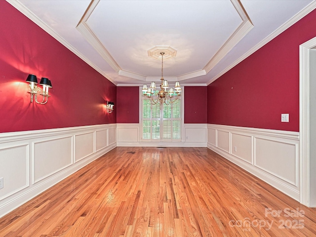 16511 Bridgehampton Club Dr, Charlotte, NC 28277 - unfurnished dining area featuring a raised ceiling, a chandelier, a wainscoted wall, wood finished floors, and ornamental molding