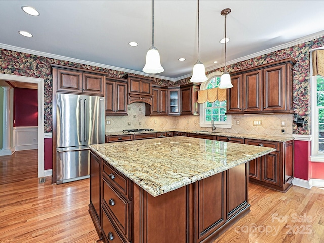 16511 Bridgehampton Club Dr, Charlotte, NC 28277 - kitchen featuring appliances with stainless steel finishes, a sink, light wood-style flooring, light stone countertops, and ornamental molding