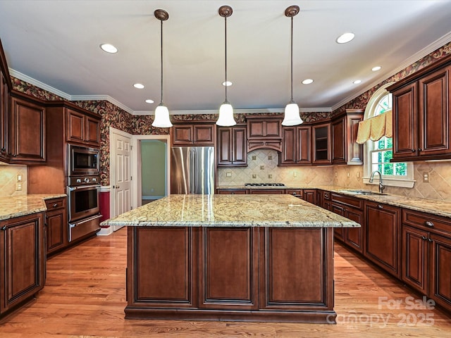 16511 Bridgehampton Club Dr, Charlotte, NC 28277 - kitchen with appliances with stainless steel finishes, a sink, a warming drawer, a center island, and light wood-style flooring
