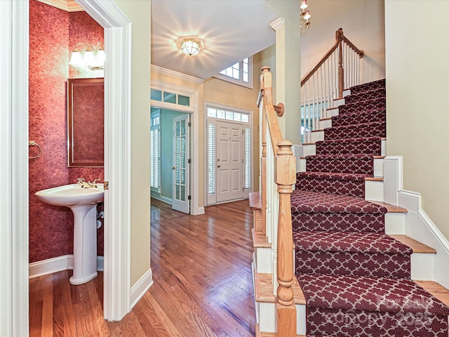 16511 Bridgehampton Club Dr, Charlotte, NC 28277 - foyer featuring stairway, wood finished floors, baseboards, wallpapered walls, and crown molding
