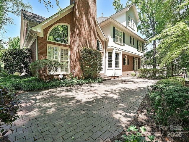 16511 Bridgehampton Club Dr, Charlotte, NC 28277 - rear view of house featuring brick siding, a chimney, entry steps, and stucco siding