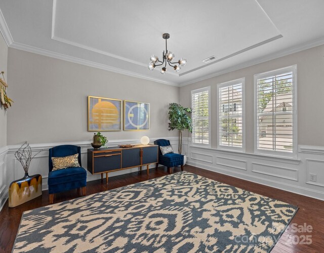 sitting room featuring a raised ceiling, a notable chandelier, dark wood-style flooring, and visible vents